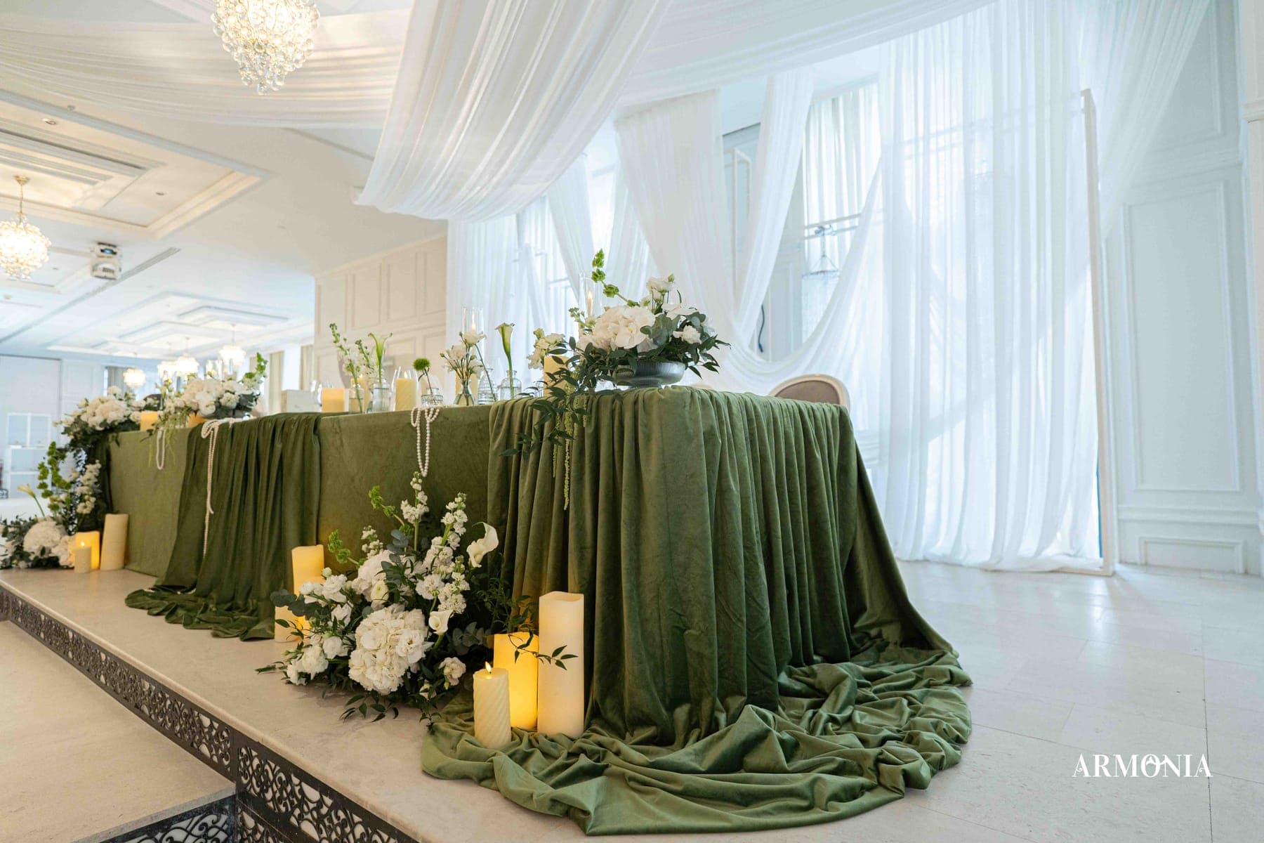 Prezidiul în catifea verde, cu drapaje albe și candelabru deasupra