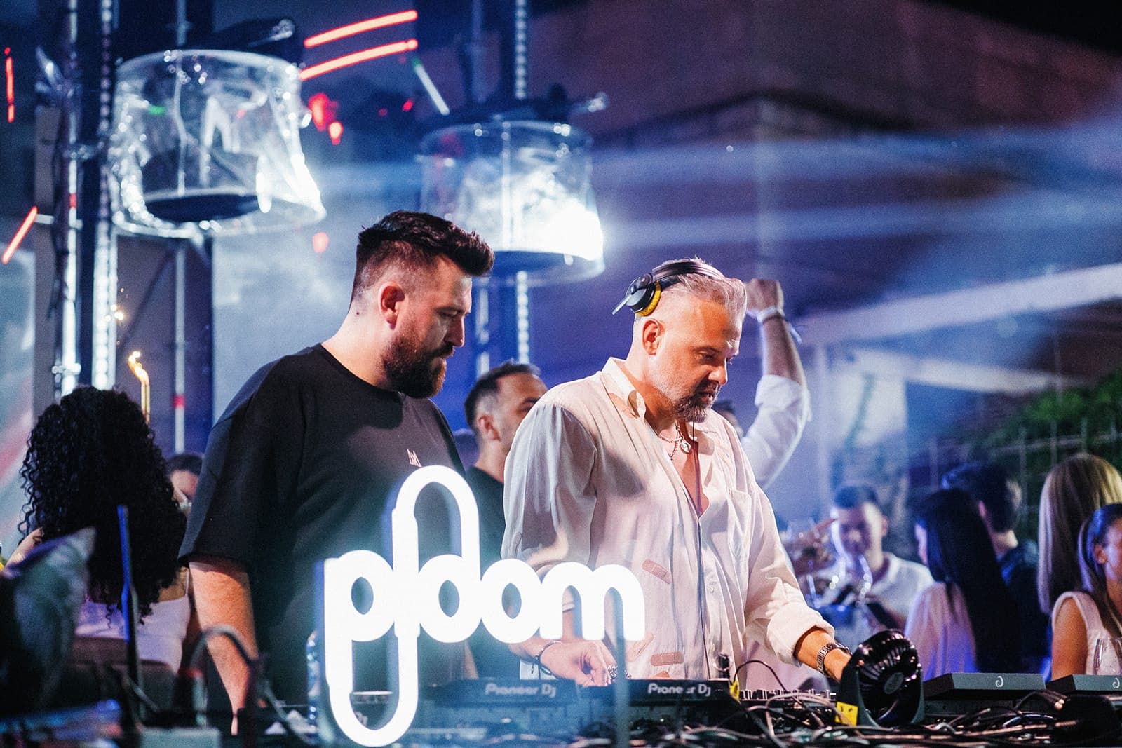 Doi DJ la pupitru, în lumină albastră