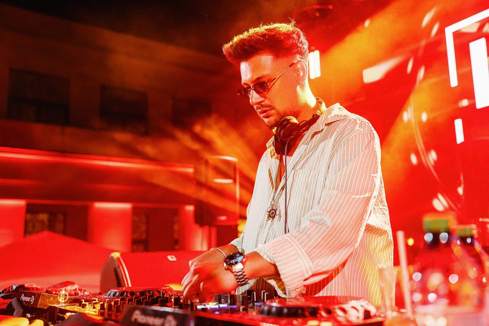 DJ mixând, în lumină portocalie