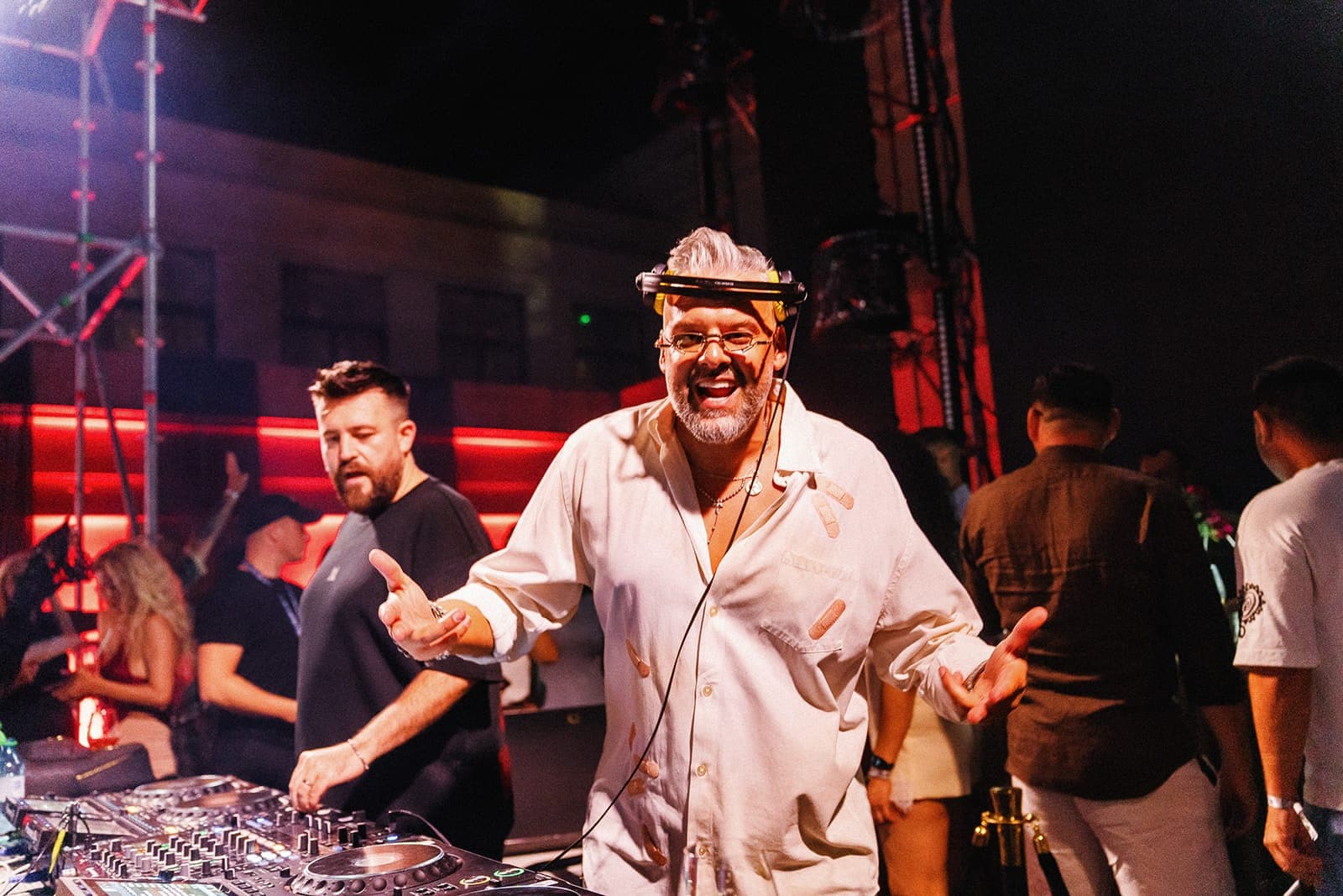 DJ în cămașă roz, mixând în fața publicului