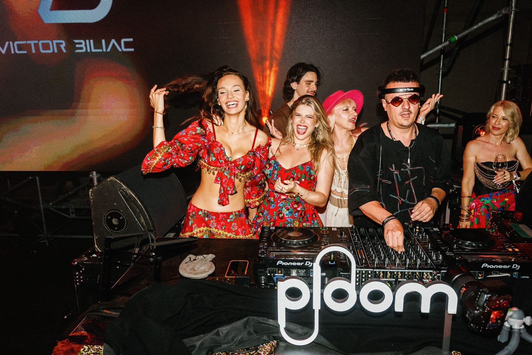 Invitate dansând la pupitrul de DJ, în lumini roz
