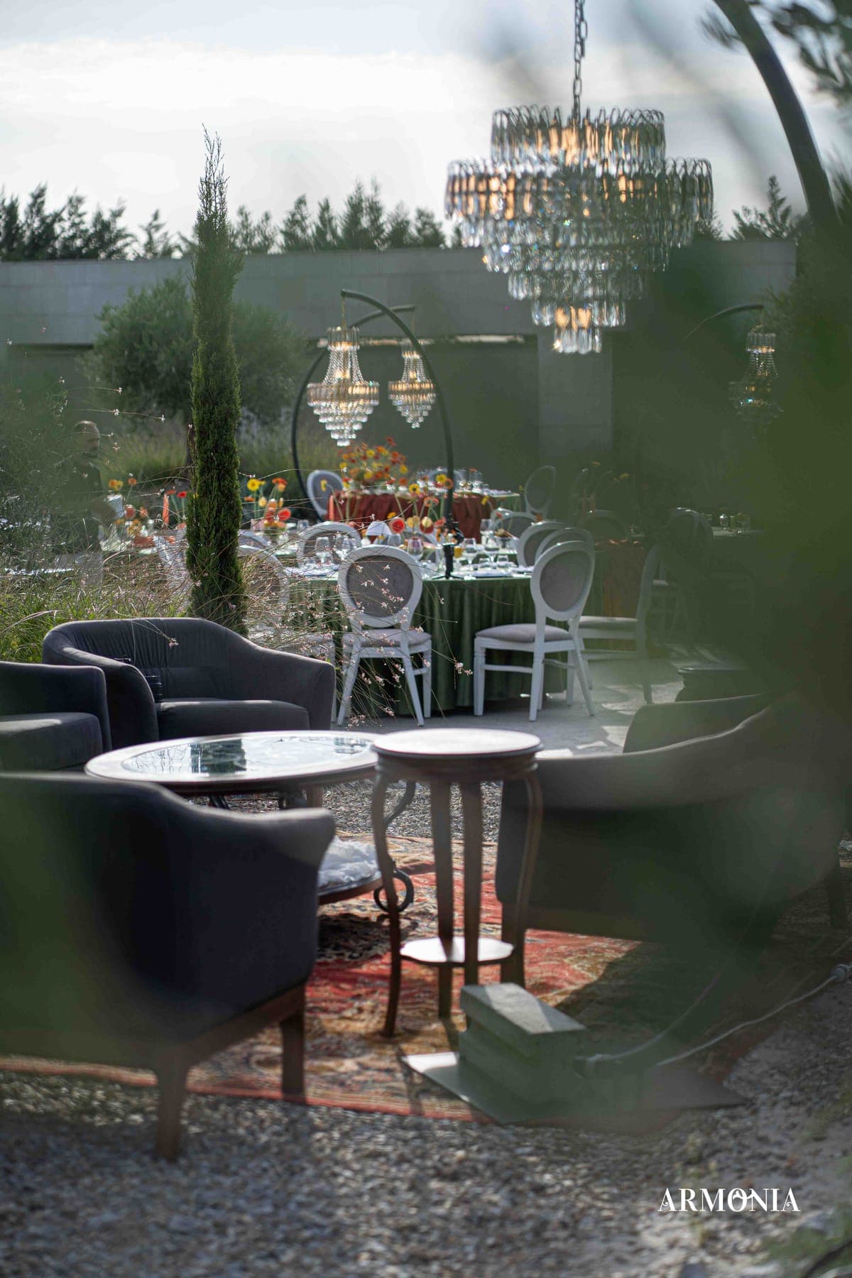 Fotolii de lounge la căderea serii, cu mesele din grădină în fundal