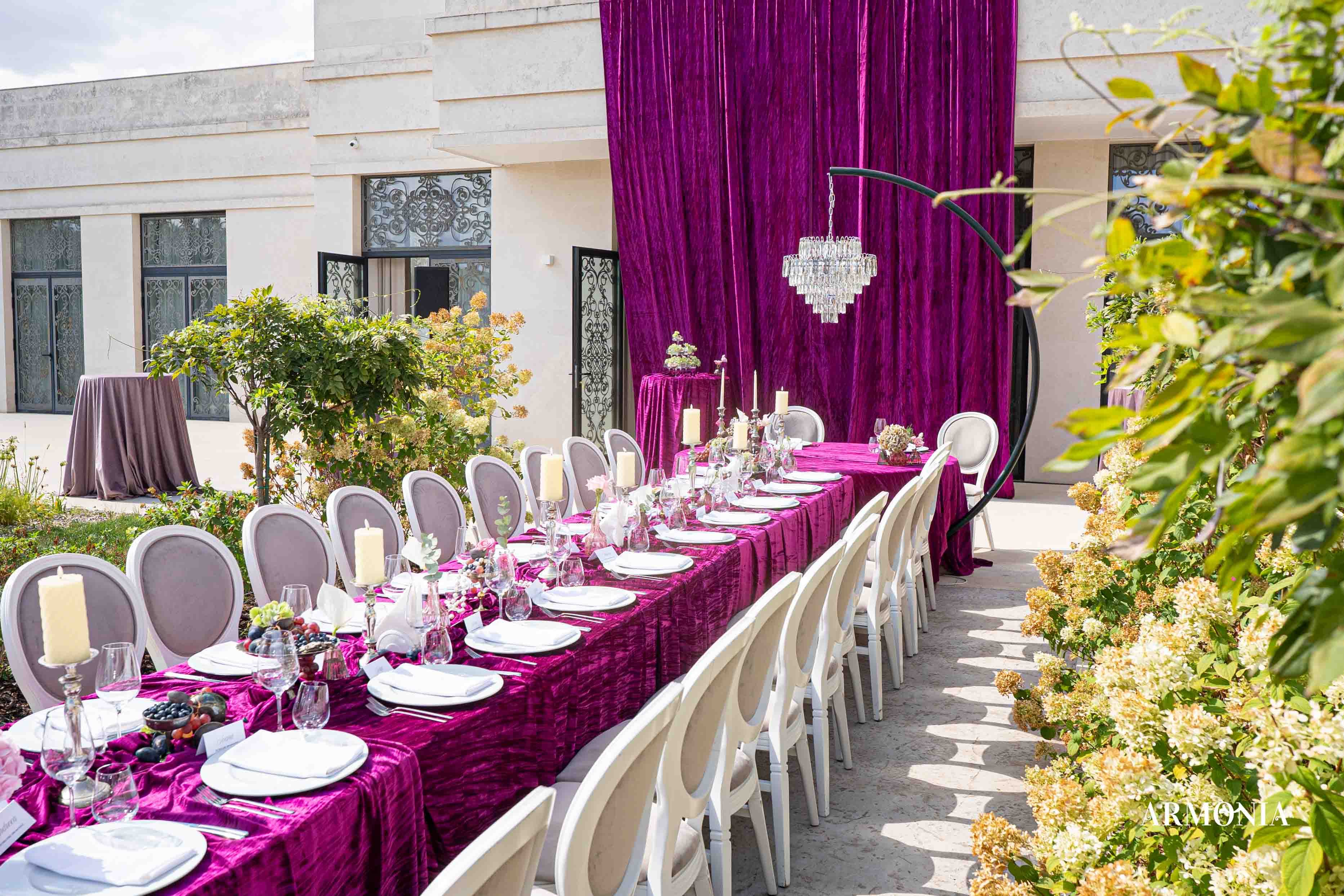 Masă fucsia cu sfeșnic de argint și pahare de cristal